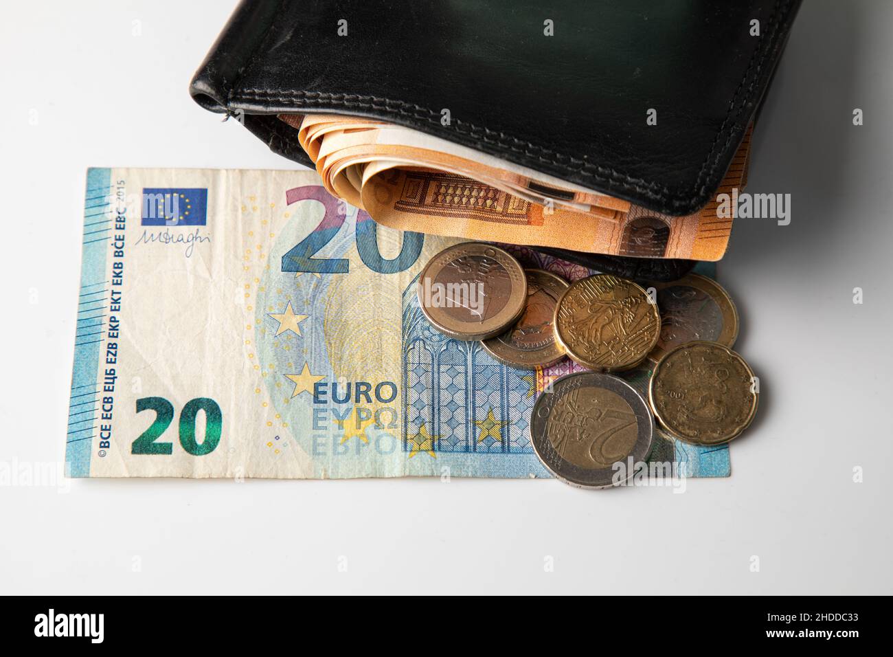 Portafoglio nero maschile pieno di contanti e banconote da venti euro con monete Foto Stock
