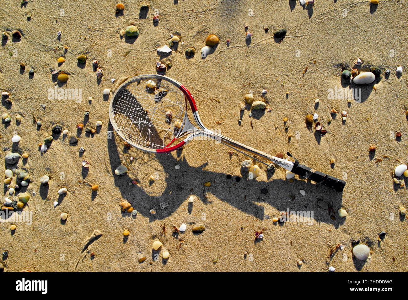 Il vecchio racket di Badminton rotto si lava sulla sabbia della spiaggia. Foto Stock