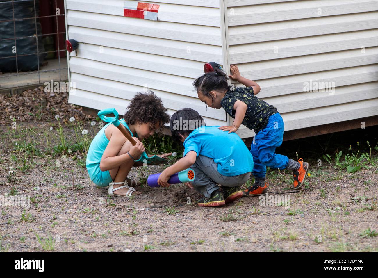 Balsam Lake, Wisconsin. Amici multietnici giocano insieme facendo pozze di fango durante un soggiorno di fine settimana in una cabina. Foto Stock