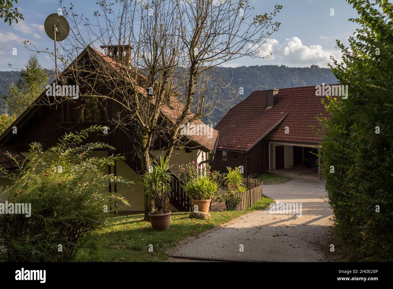 Foto di una tipica casa suburbana austriaca, una singola unità familiare con una strada panoramica di fronte, in Carinzia. Foto Stock