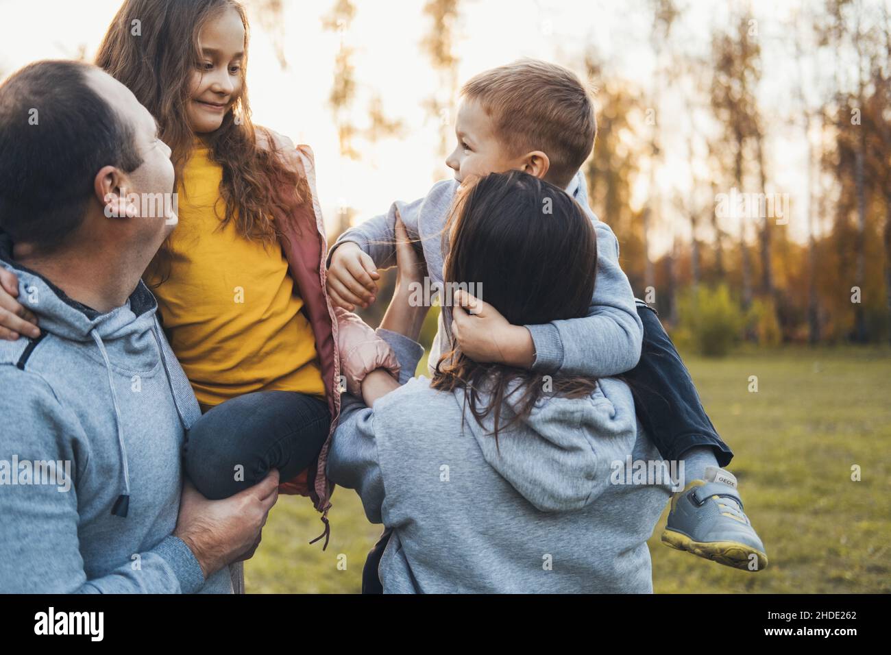 Coppia che porta due bambini che trascorrono il tempo insieme. Giornata in famiglia. Foto Stock