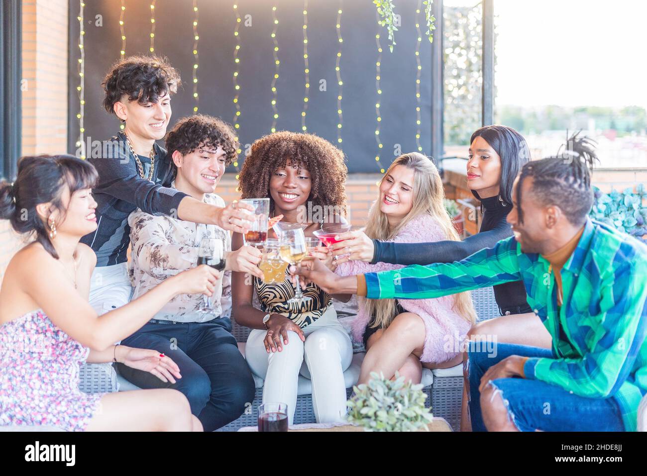 Gli amici tostano con bevande in un terrance Foto Stock