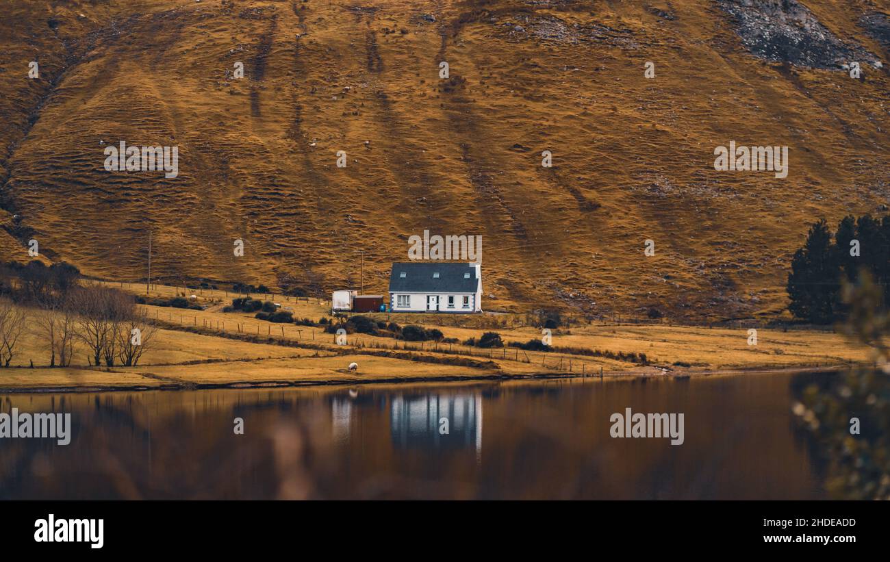 Vista panoramica di una casa che si riflette su un lago tranquillo autunnale paesaggio di montagna sfondo Foto Stock