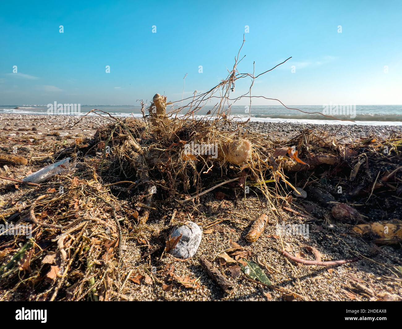 Si versano rifiuti sulla spiaggia della grande città. Svuotare le bottiglie di plastica sporche usate. Mare sporco spiaggia sabbiosa. Inquinamento ambientale. Problema ecologico Foto Stock
