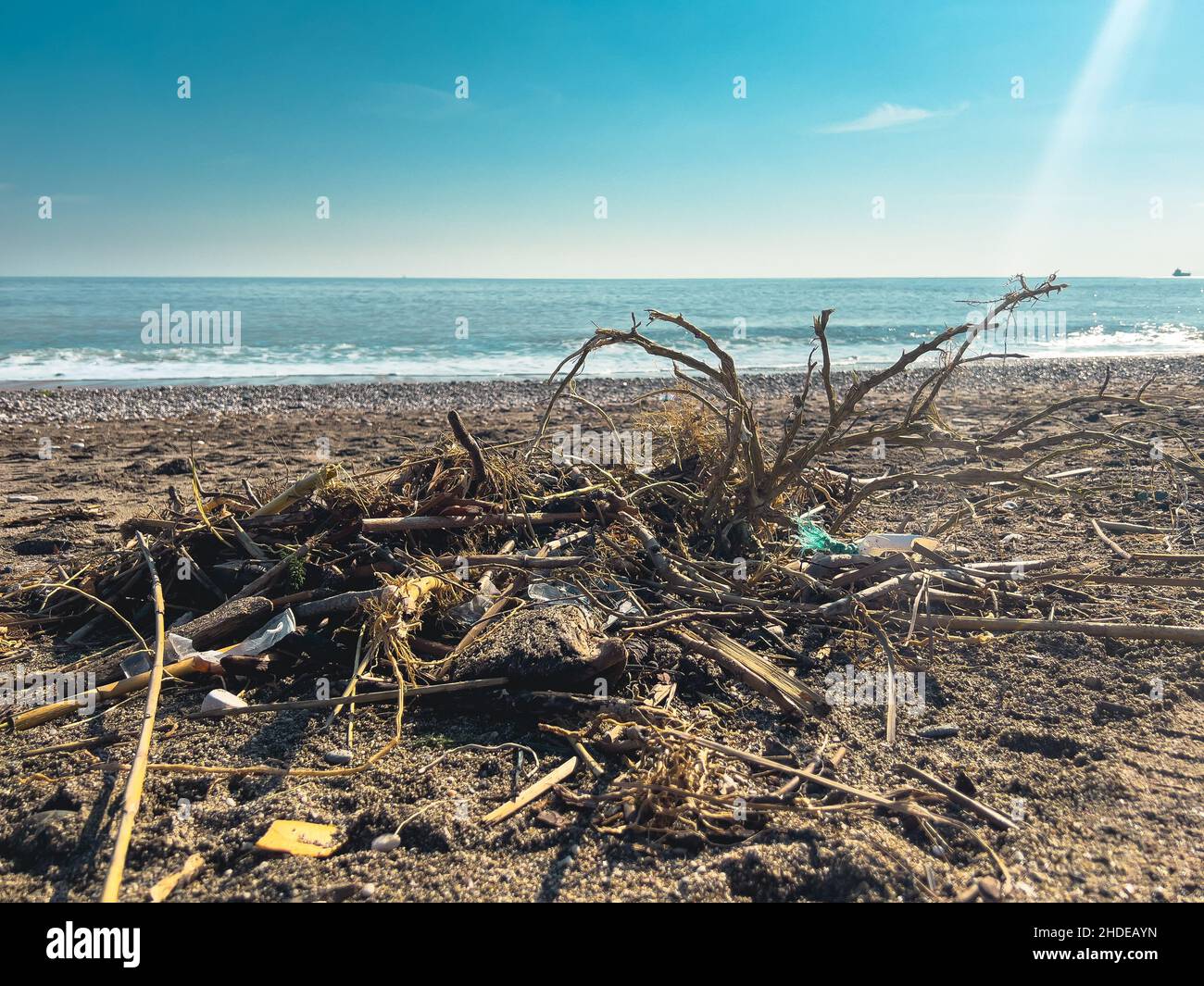 Si versano rifiuti sulla spiaggia della grande città. Svuotare le bottiglie di plastica sporche usate. Mare sporco spiaggia sabbiosa. Inquinamento ambientale. Problema ecologico Foto Stock