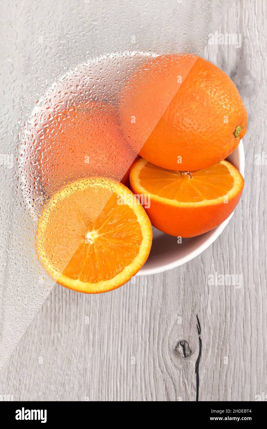 Riassunto frutta di agrume arancione e vetro umido con gocce d'acqua Foto Stock