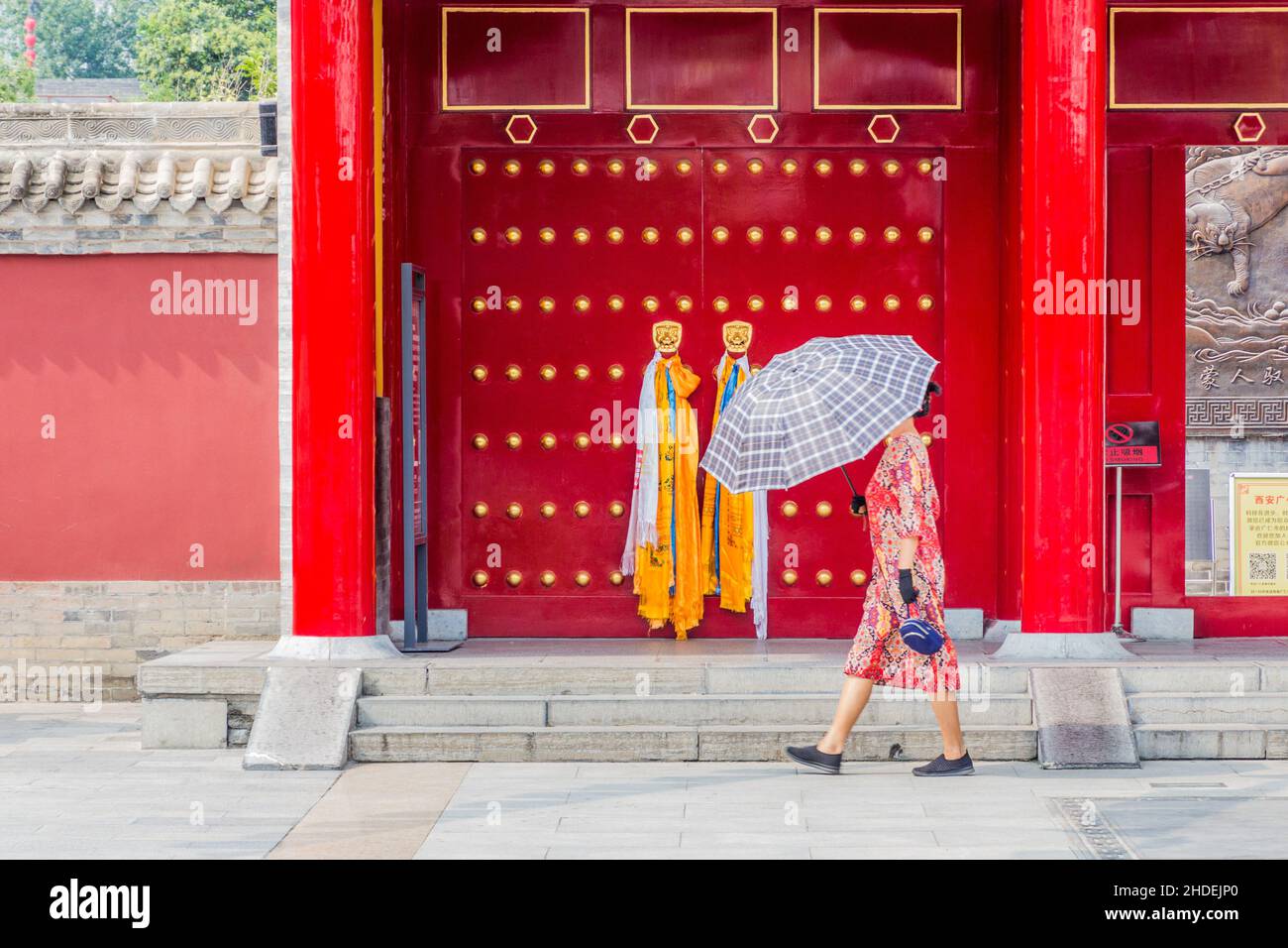 XI'AN, CINA - 5 AGOSTO 2018: Donna con ombrello passa davanti al Tempio di Guangren lama a Xi'an, Cina Foto Stock