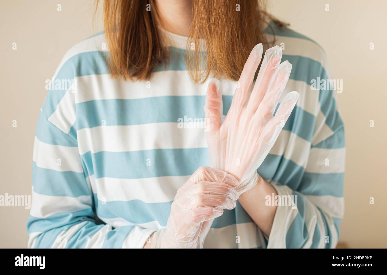 Donna indossando guanti in vinile trasparente Foto Stock