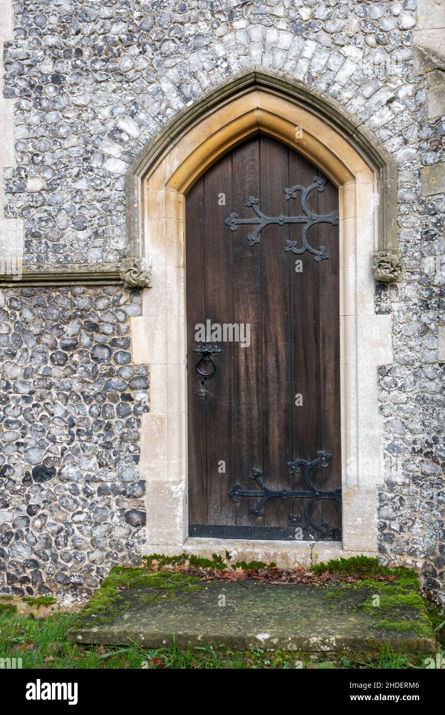Fanghetta in pietra lungo il muro di selce a fondale sopra l'arco della porta a St Michael e All Angels, Boulge, Suffolk, UK Foto Stock