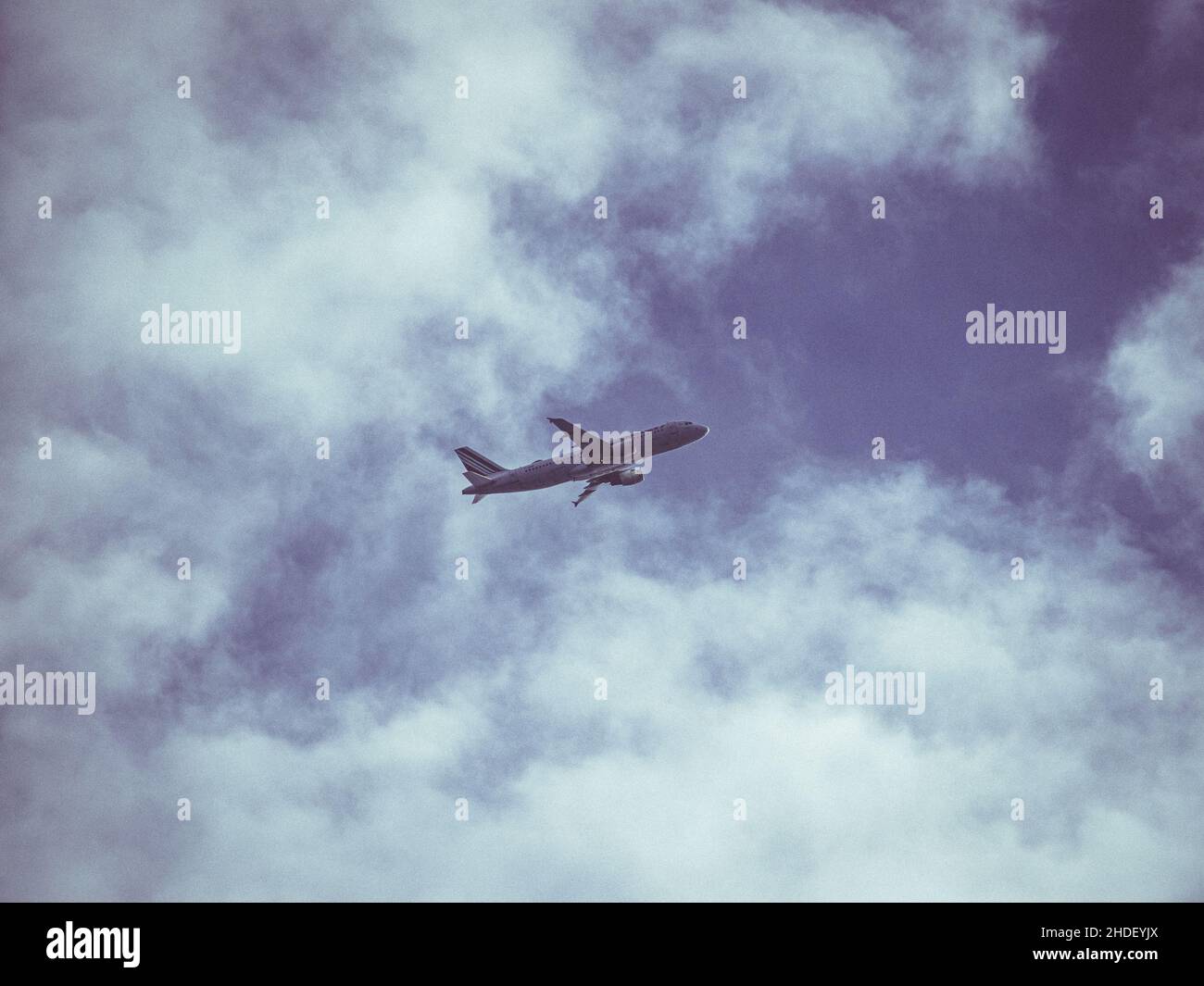 Aereo che vola in alto con cielo blu nuvoloso lasciando l'aeroporto di Atene Foto Stock