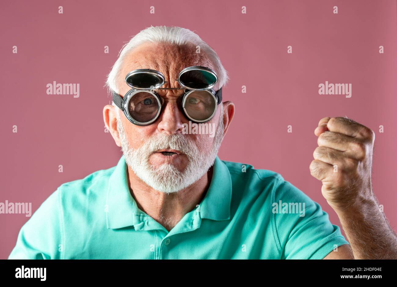 Ritratto di uomo anziano umoristico con occhiali di protezione che si sente arrabbiato e guardando la macchina fotografica. Foto Stock