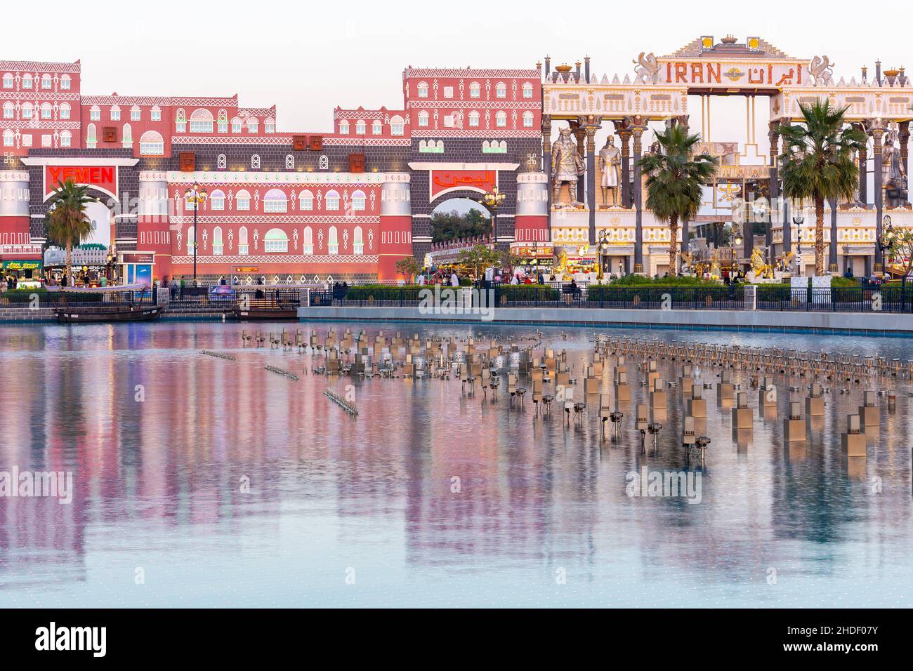 Dubai, Emirati Arabi Uniti, 10.01.21. Parco divertimenti Global Village a Dubai con padiglioni nazionali Yemen e Iran, edifici che si riflettono in acque turchesi lisce. Foto Stock