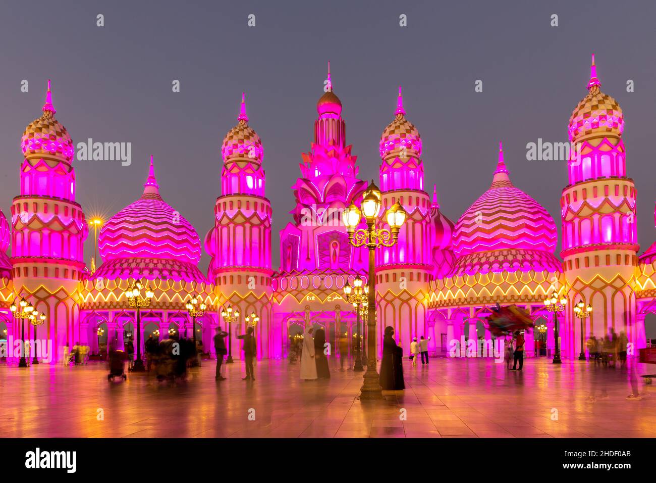 Dubai, Emirati Arabi Uniti, 10.01.21. Parco divertimenti Global Village di notte con torri e cupole in stile arabo illuminate di rosa. Foto Stock