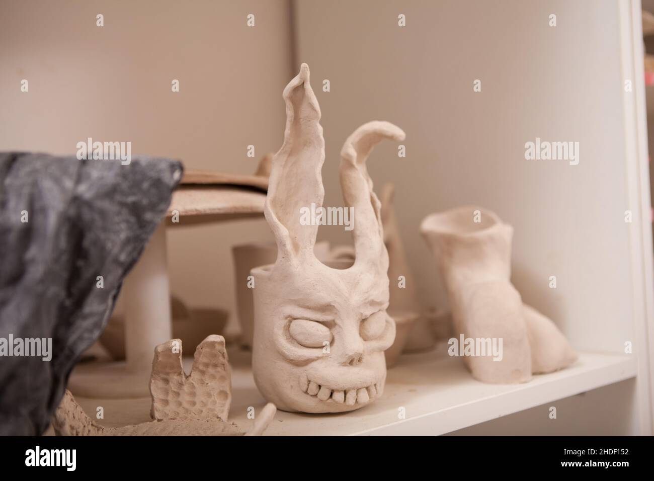 Primo piano di una tazza di terracotta in terracotta sullo scaffale dello studio di ceramica Foto Stock