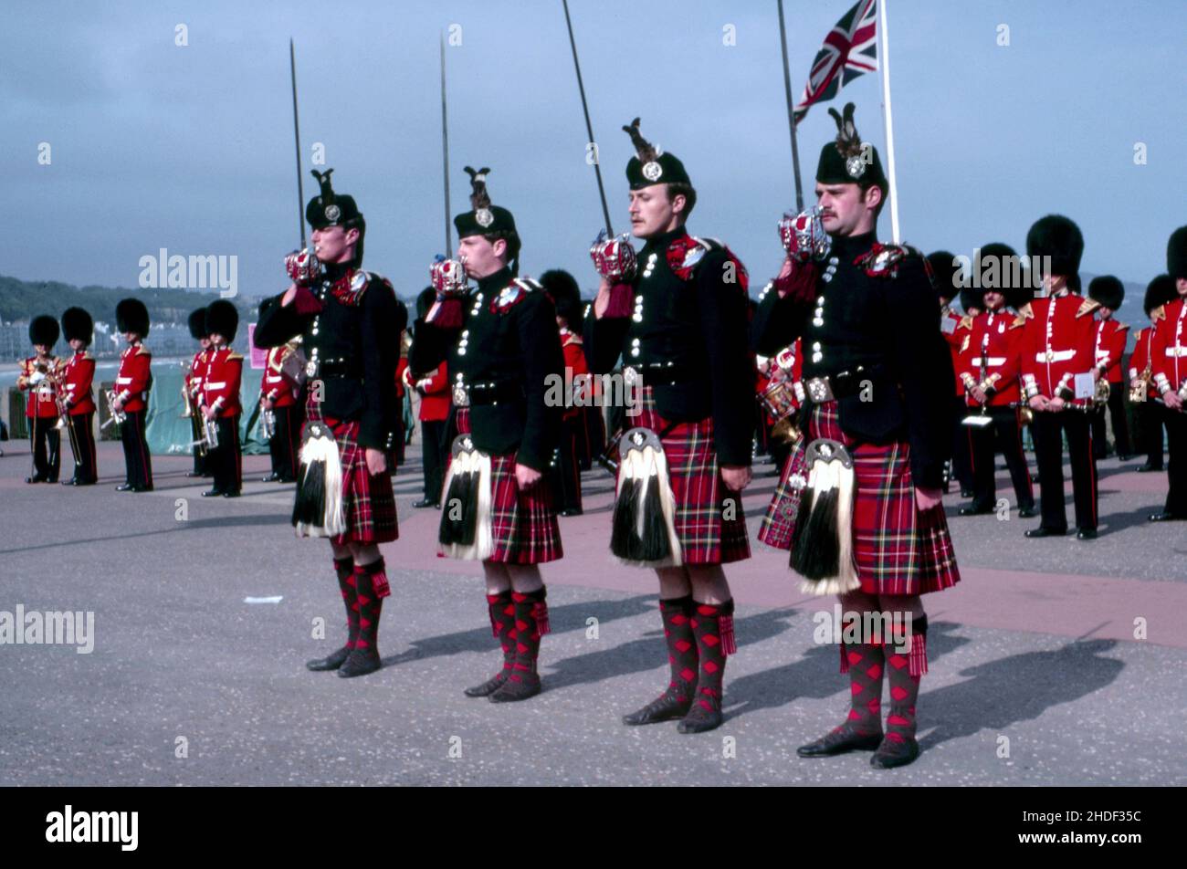 Quattro membri della Guardia scozzese indossano pantofole da ballo invece di stivali da combattimento durante una speciale performance band sullo sfondo in uniforme militare Foto Stock