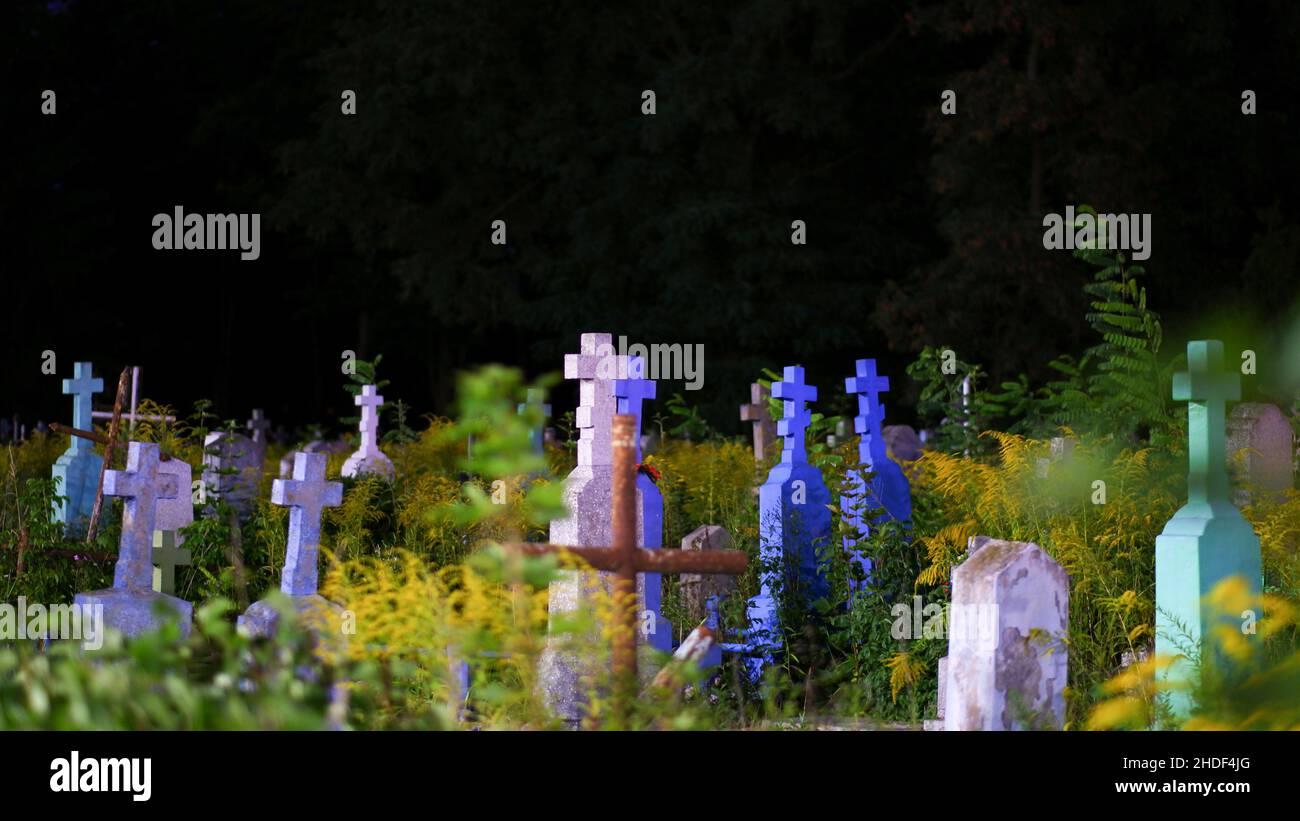 Vista sul cimitero della città ortodossa in estate di notte. Vecchie lapidi multicolore e croci. Foto Stock