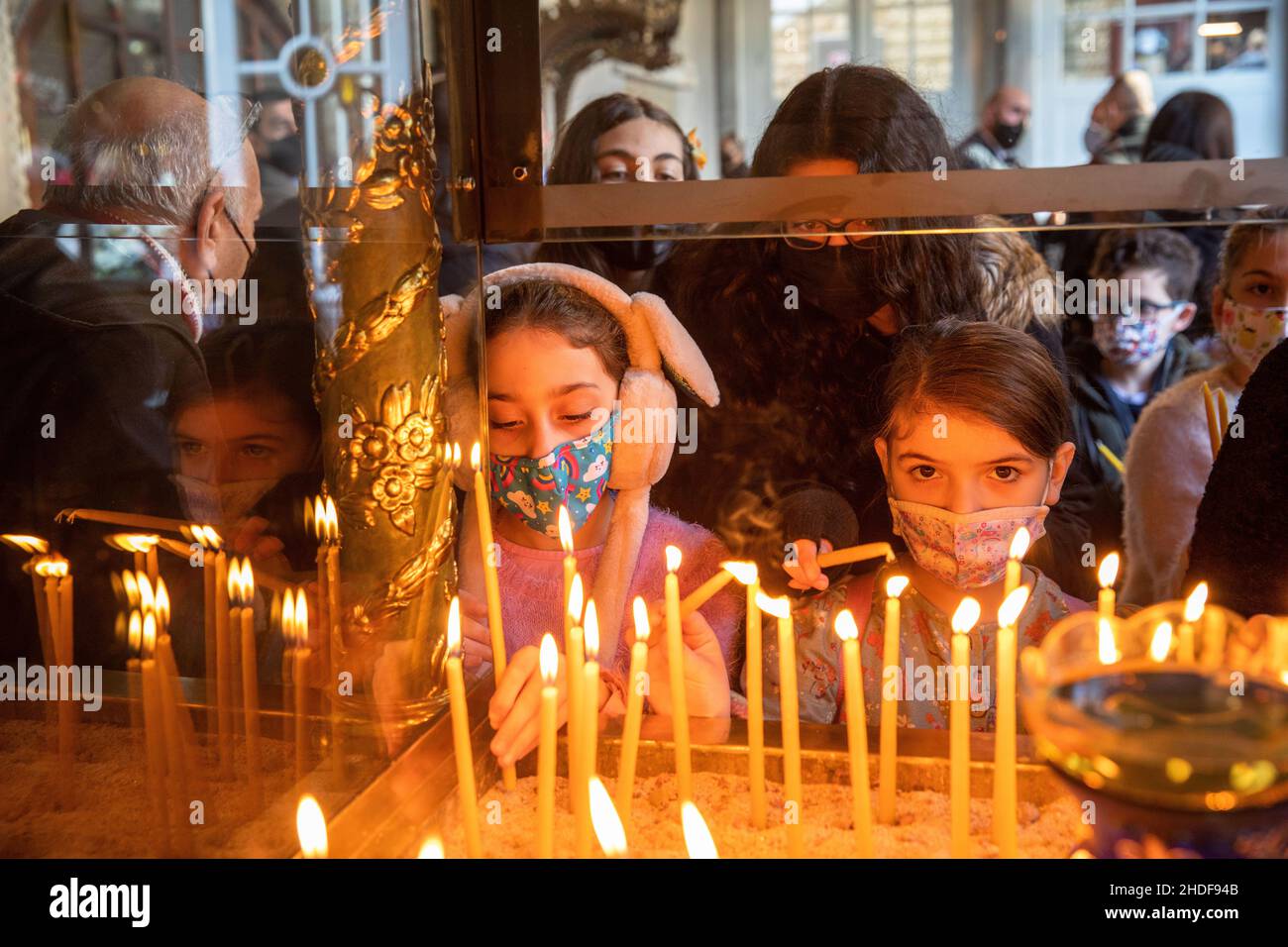 ISTANBUL, TURCHIA - 06 gennaio 2022: I bambini accendono una candela e pregano nella chiesa patriarcale di San Giorgio, come parte delle celebrazioni del giorno dell'Epifania A. Foto Stock