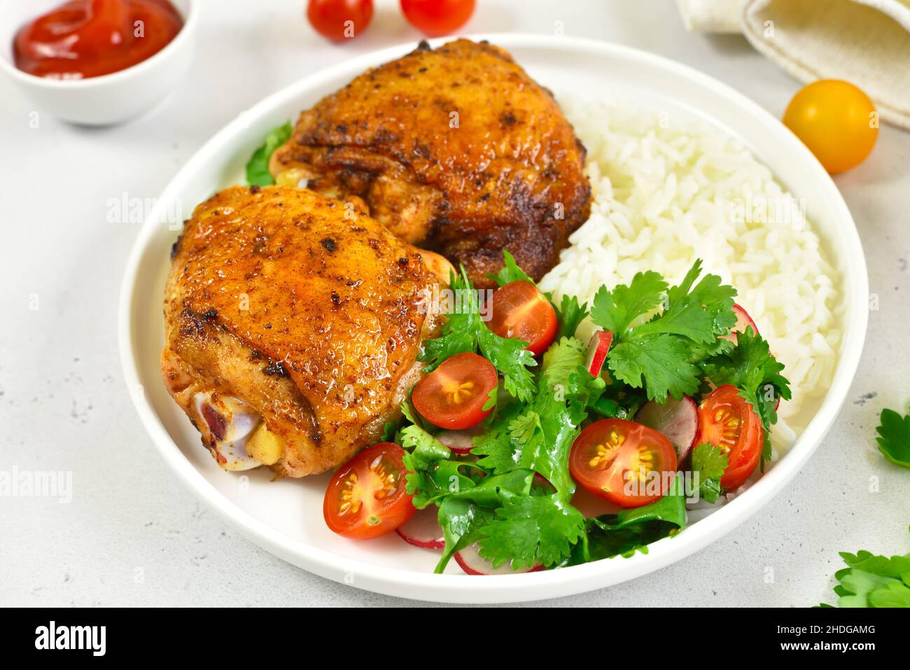 Cosce di pollo fritte con verdure e riso sul piatto Foto Stock