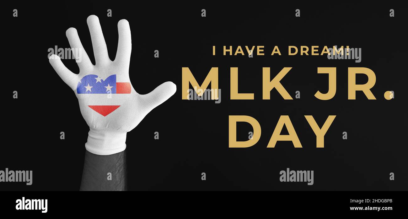 Giornata MLK. Mano di persona afro-americana in guanto bianco con American Flag Heart. Sfondo nero. Happy Martin Luther King Day Concept. Foto Stock