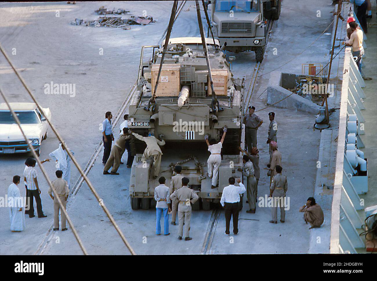 Un carro armato sospeso di Chieftain che è guidato su un trasportatore di carro armato sulla banchina dopo essere stato sollevato dalla nave di carico M/V Ibn Rushd in Kuwait, 10th giugno 1977 Foto Stock