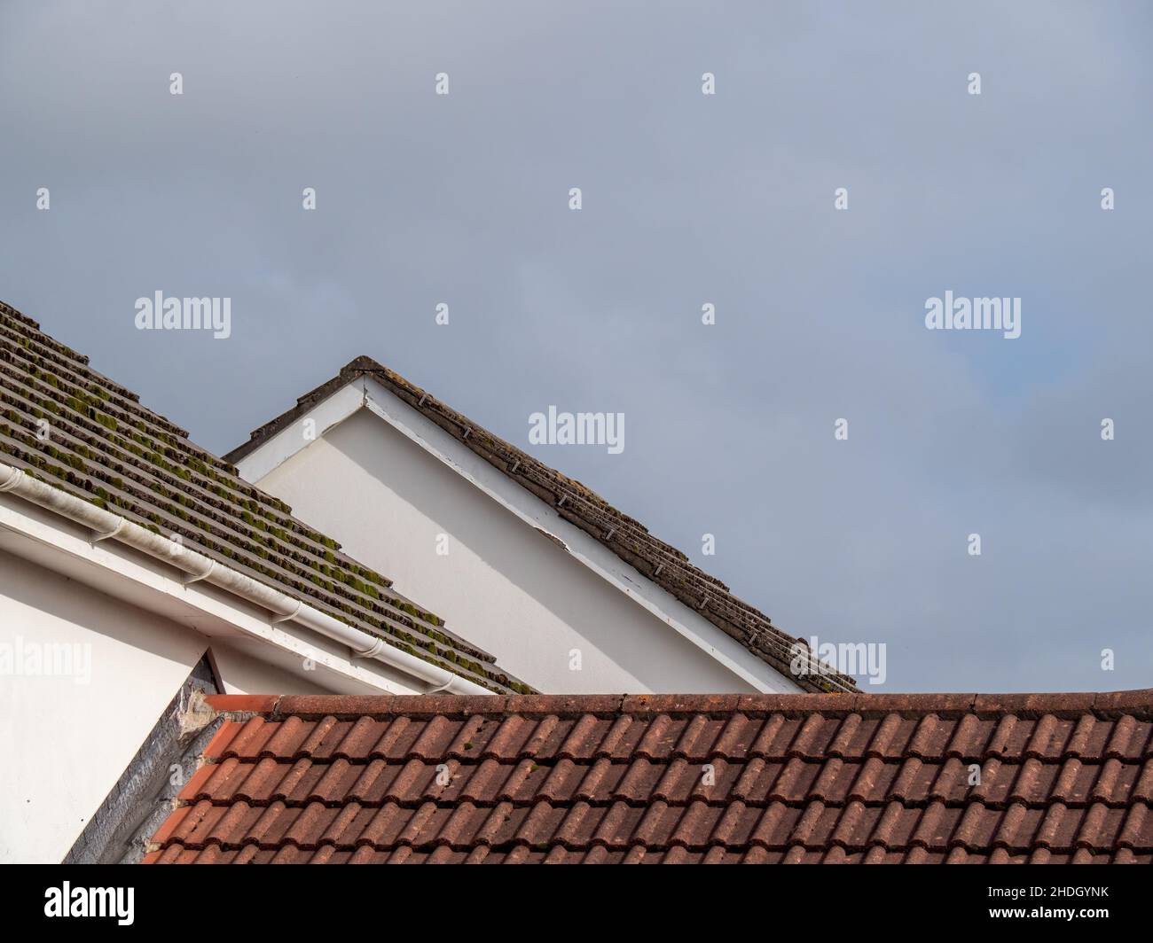 Tetti suburbani del Regno Unito, tegole rosse, cielo grigio. Foto Stock