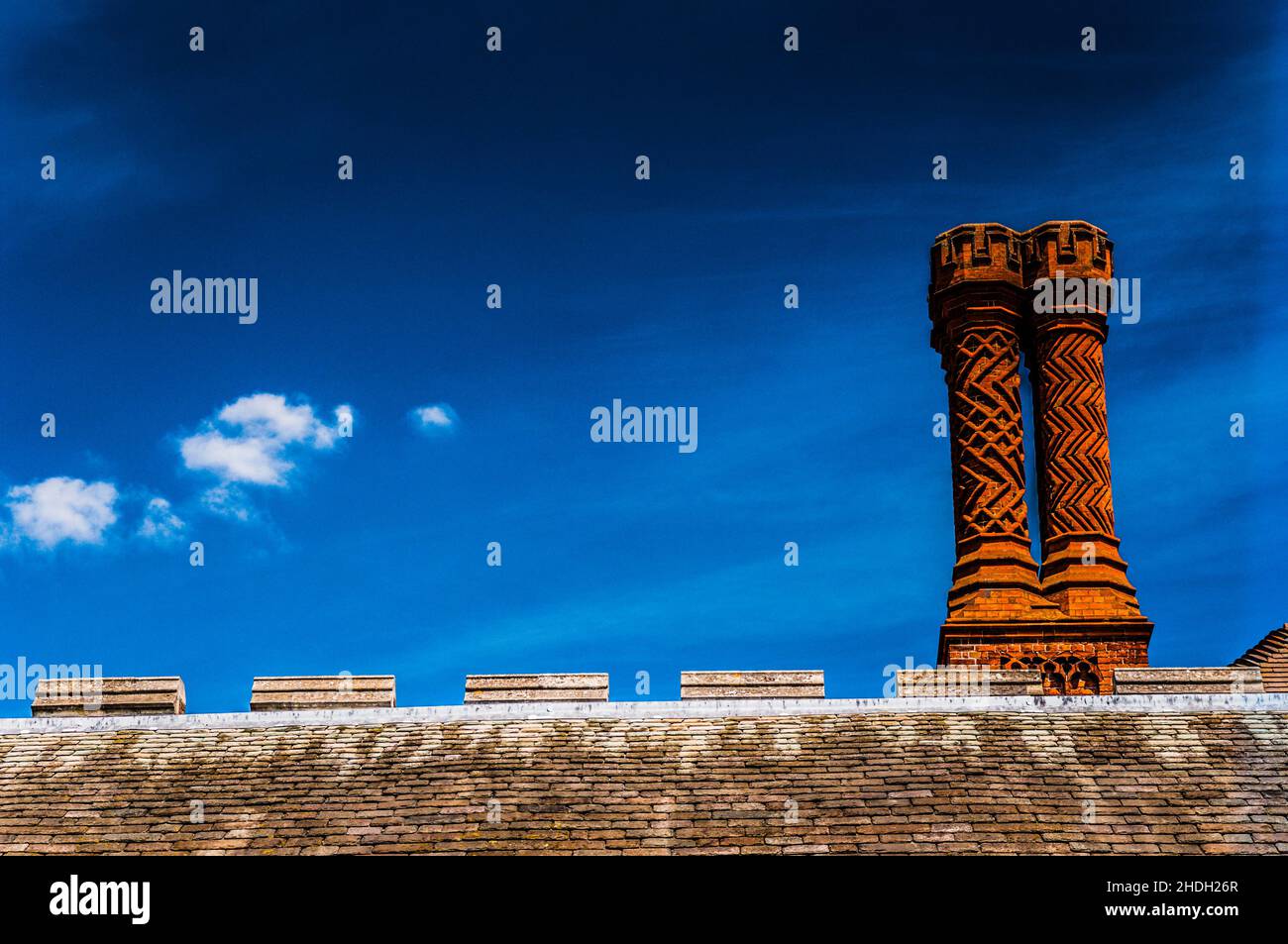 Tudor Chimney Stacks sul tetto contro un cielo blu Foto Stock