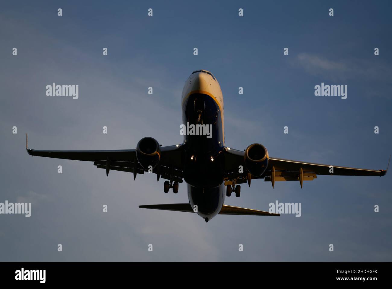 Passeggeri aerei commerciali che volano sopra le nuvole alla luce del tramonto. Concetto di viaggio veloce, vacanze e affari. Foto Stock