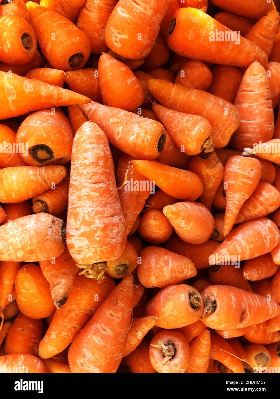 Sfondo di cibo full frame di piccole carote Chantenay patrimonio su una bancarella di mercato con spazio copia Foto Stock