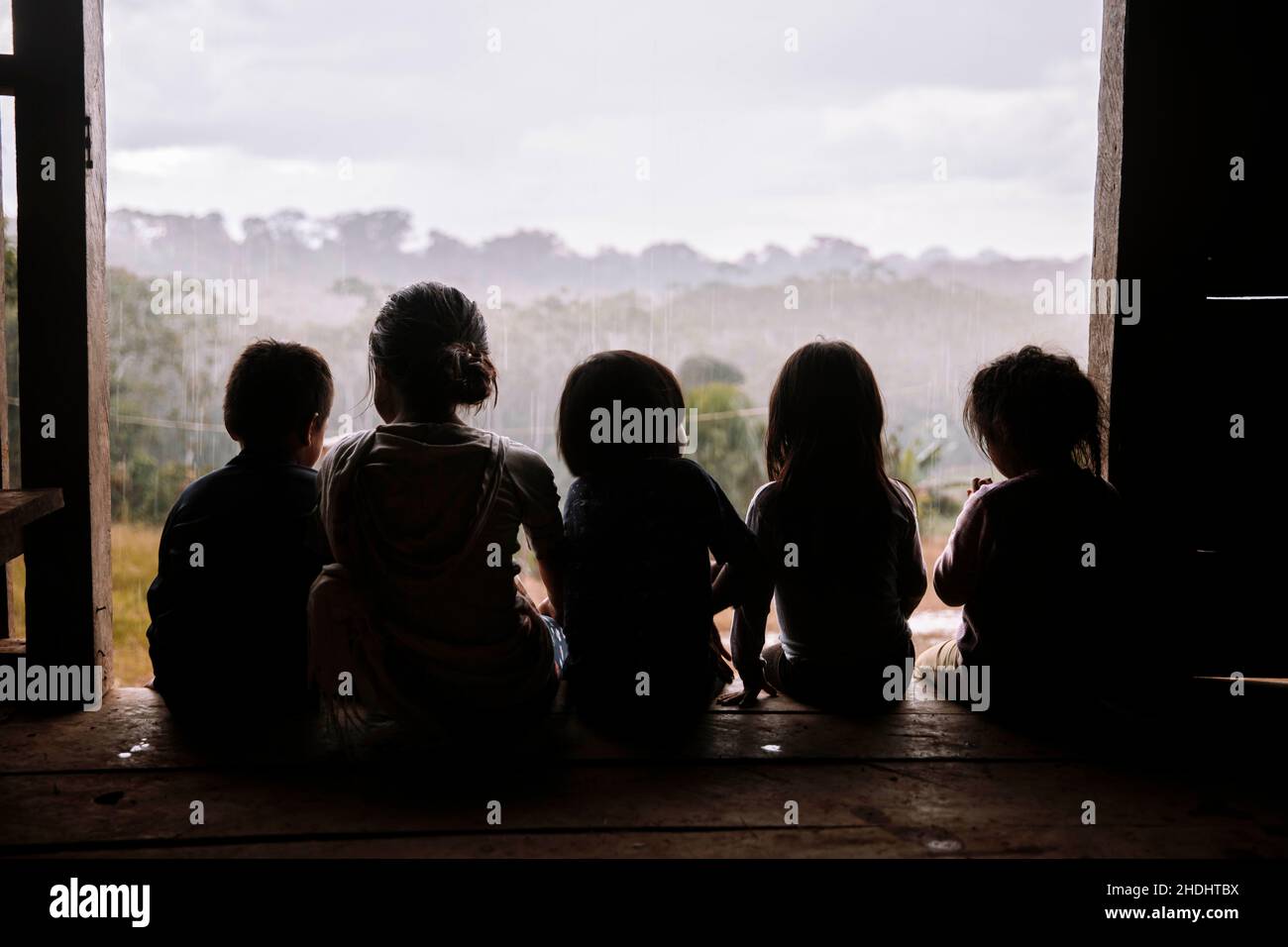 Bambini indigeni seduti nella foresta pluviale amazzonica, Ecuador Foto Stock