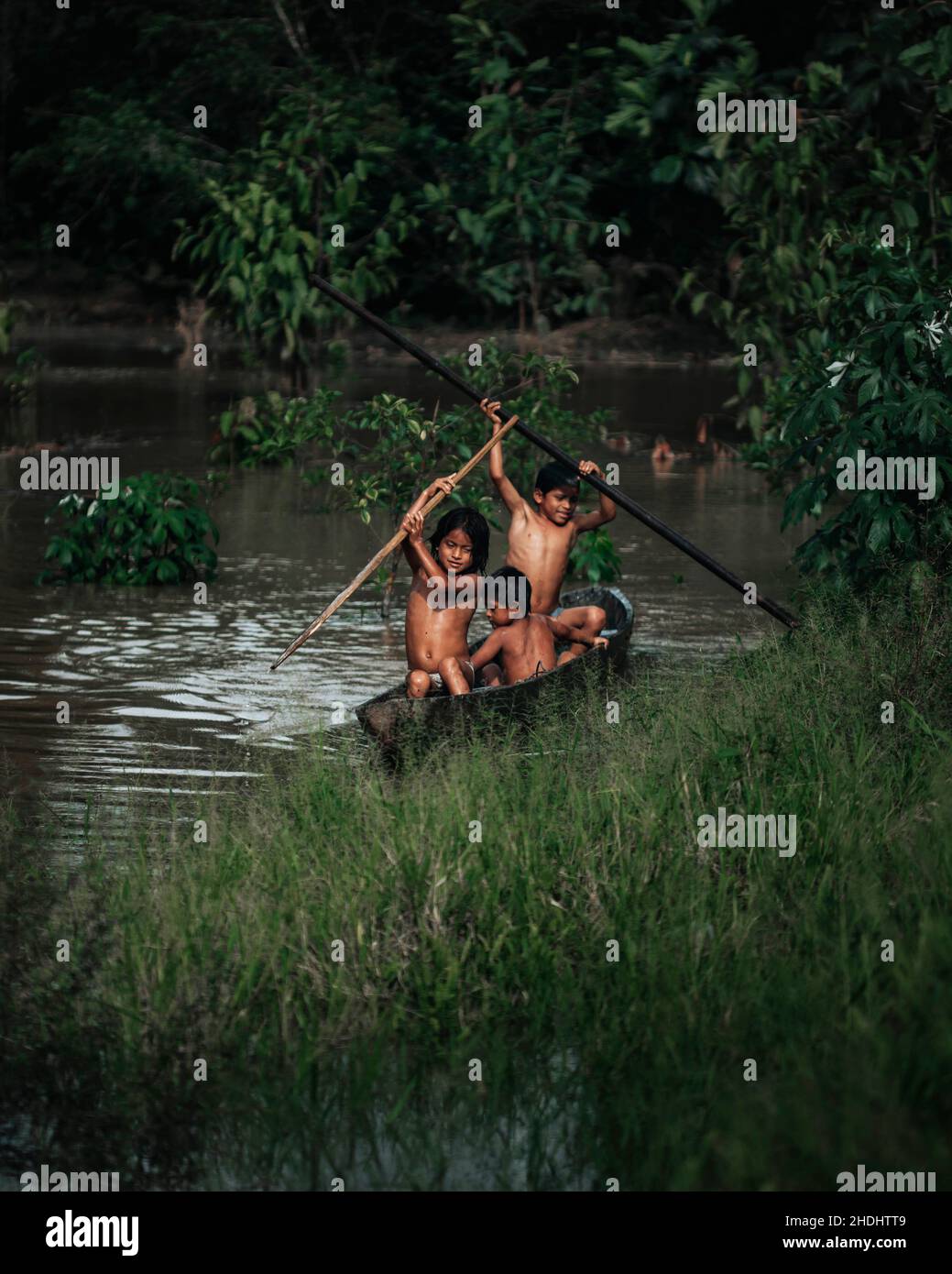 Bambini indigeni che canottano lungo il fiume Amazzonia, Ecuador Foto Stock