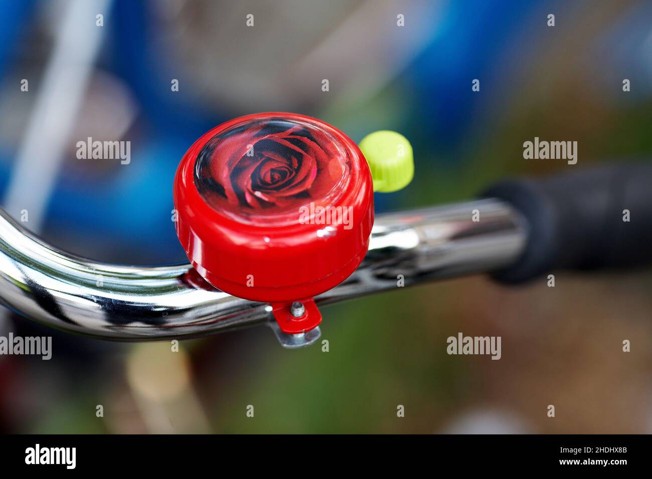 Campana della bicicletta di rose. Manubrio della bicicletta con campana con sfondo sfocato. Foto Stock