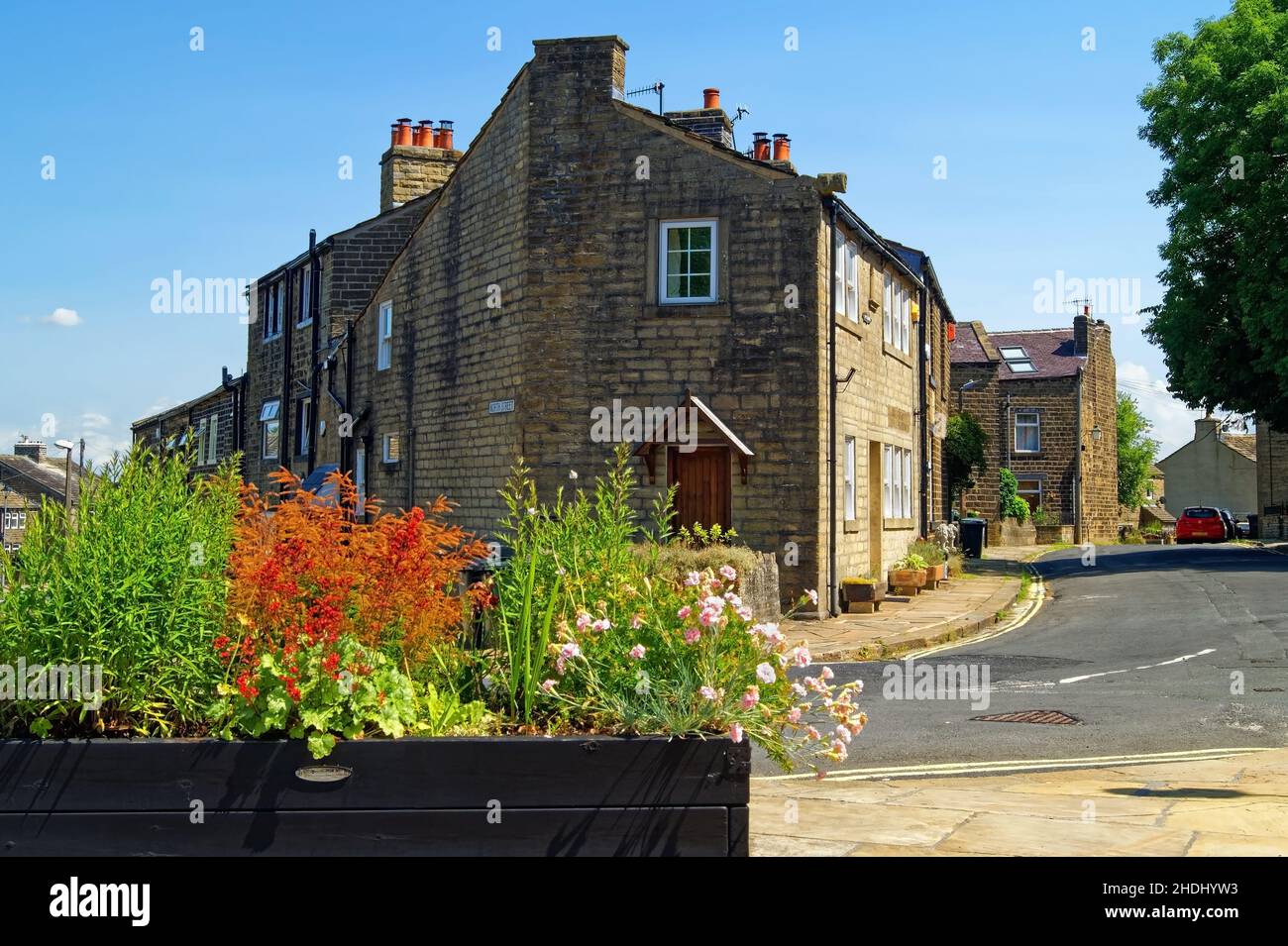 UK, West Yorkshire, Haworth, Planter con fiori all'incrocio tra West Lane e North Street Foto Stock