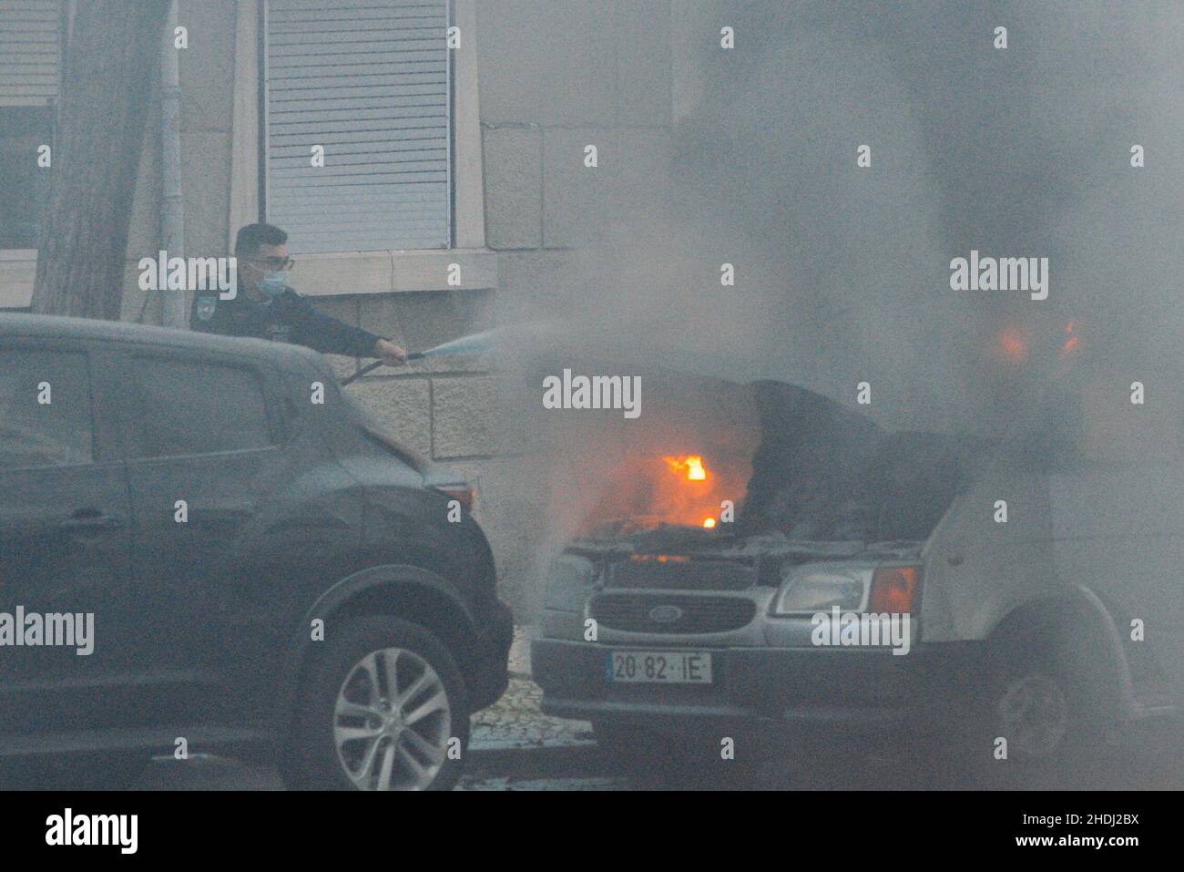 Lisbona, Portogallo - 6 gennaio 2022: Il motore di un furgone si incendia in piena luce nel centro di Lisbona, Portogallo. Polizia e vigili del fuoco assistono alla scena Foto Stock