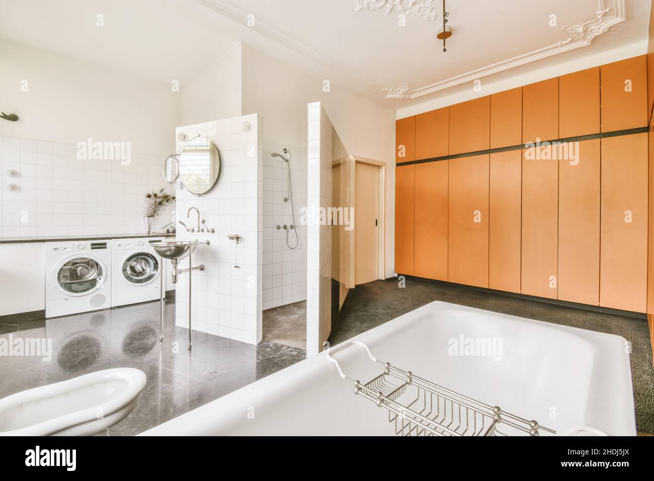 Ampio e confortevole bagno con vasca da bagno con base a zampa di gallo e pavimento grigio Foto Stock