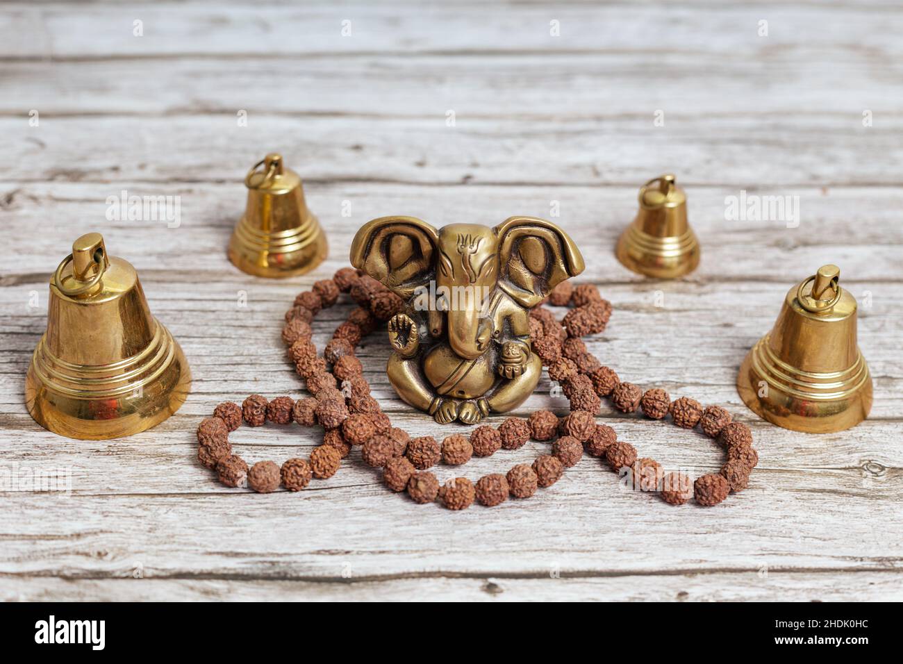 Ganesha, o Ganapati - nell'induismo, il dio della saggezza e della prosperità con la testa di un elefante. Una serie di campane rituali e un rosario di Rudraksha Foto Stock