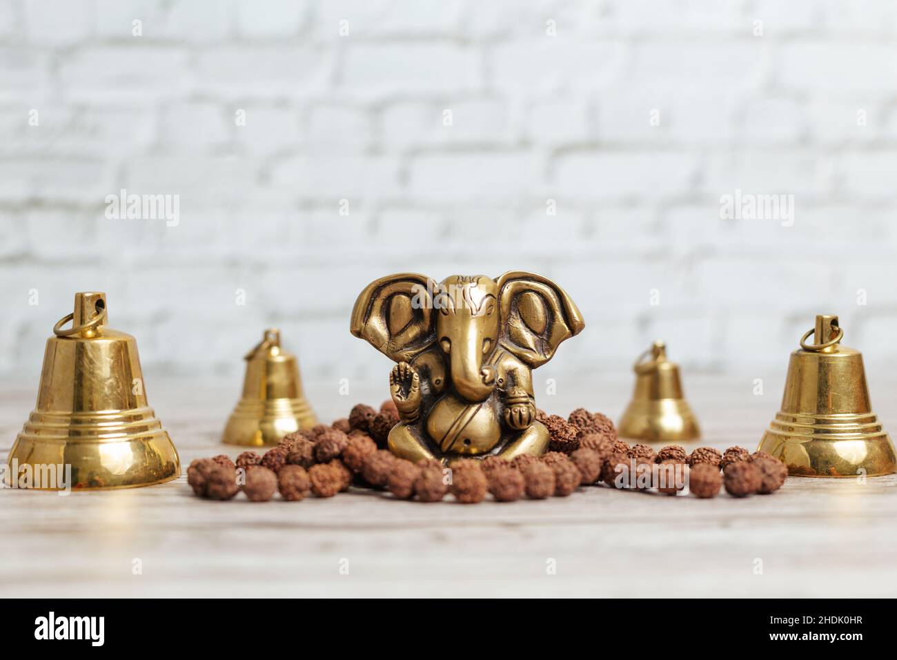 Ganesha, o Ganapati - nell'induismo, il dio della saggezza e della prosperità con la testa di un elefante. Una serie di campane rituali e un rosario di Rudraksha Foto Stock