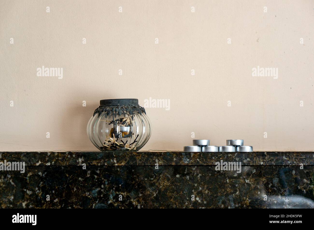 Lampada decorativa e candele da tè su un camino Foto Stock