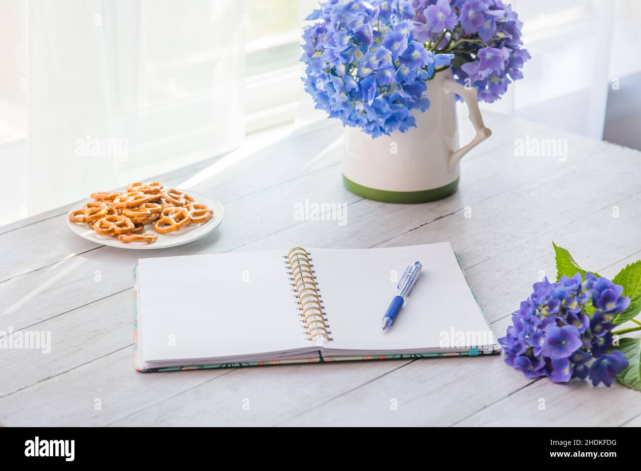 Fiori di hydrangea con il taccuino sul tavolo con spazio di copia per il testo Foto Stock