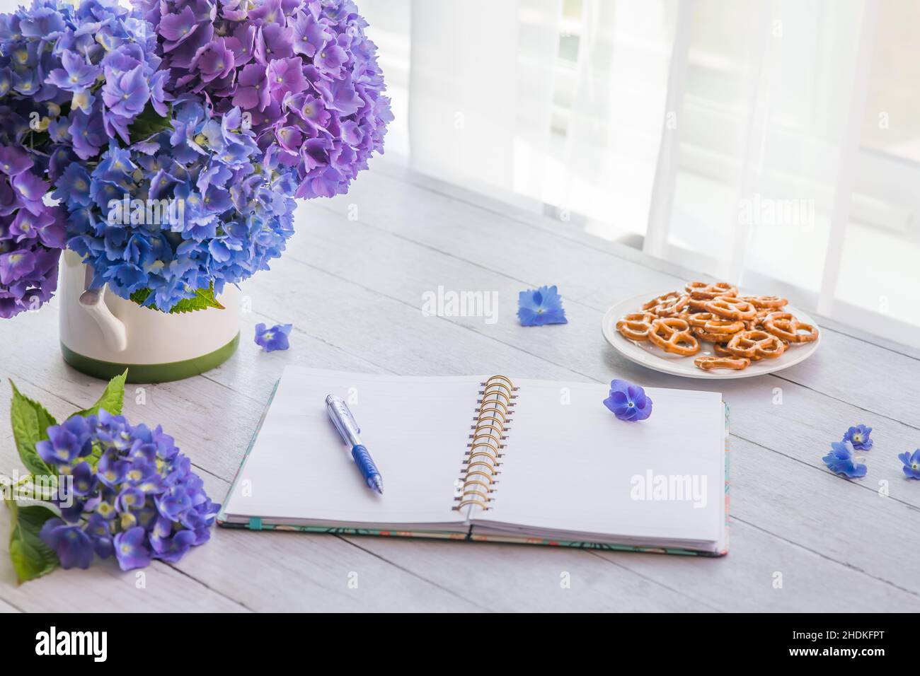 Fiori di hydrangea con il taccuino sul tavolo con spazio di copia per il testo Foto Stock