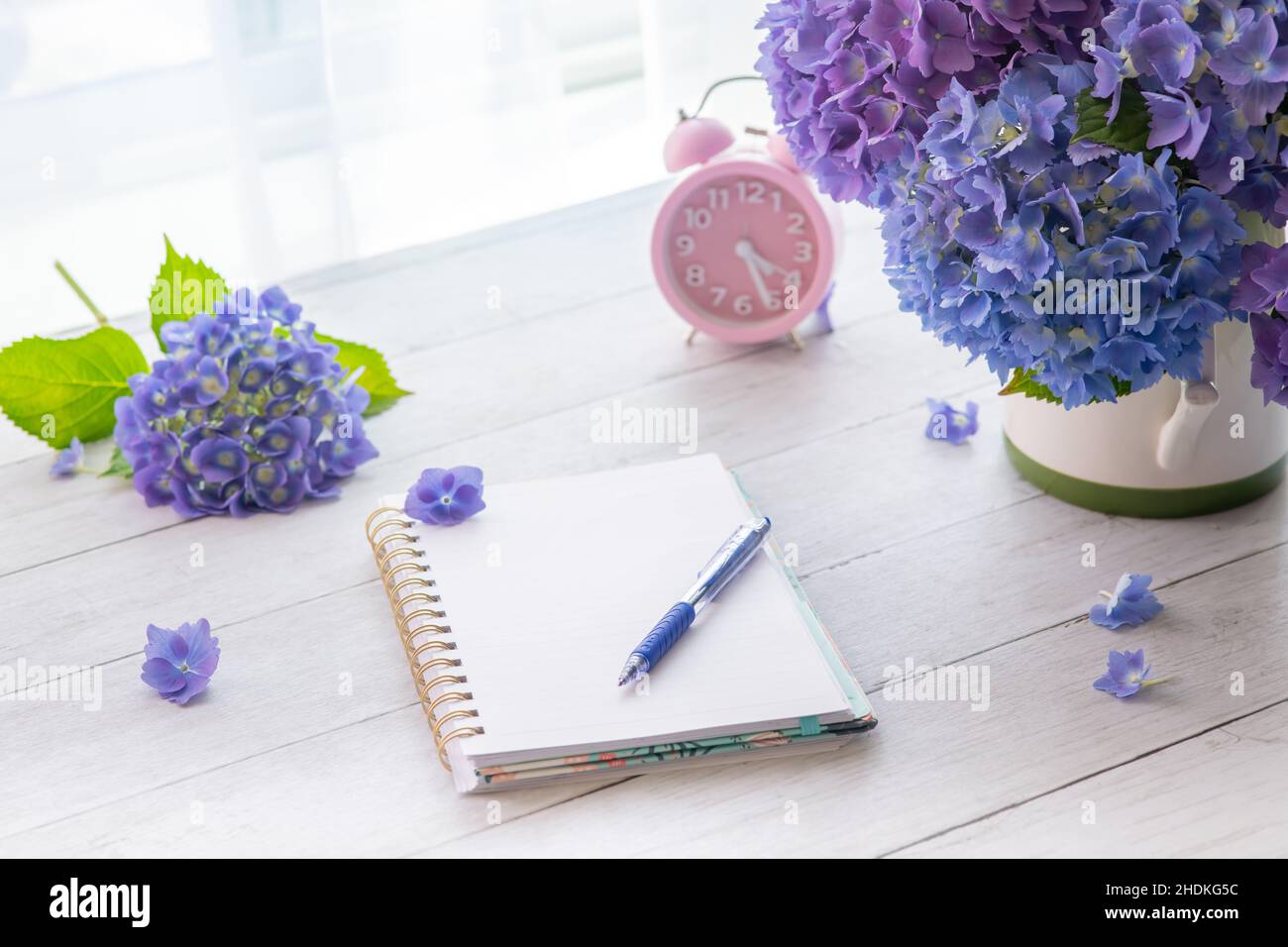 Fiori di hydrangea con il taccuino sul tavolo con spazio di copia per il testo Foto Stock
