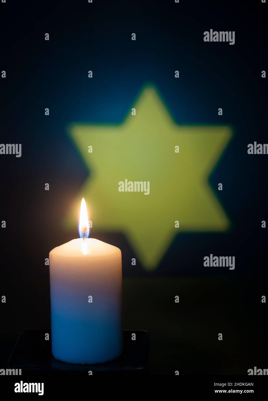 Candela che brucia e la stella di David sullo sfondo. Per il giorno del ricordo dell'Olocausto. Foto Stock