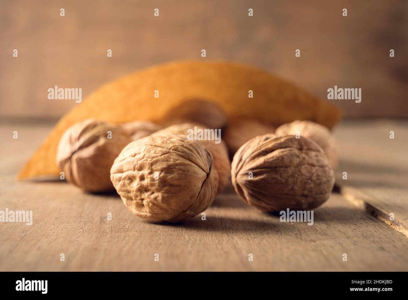 Cono di carta con dadi su un vecchio tavolo di legno in un ambiente scuro. Foto Stock