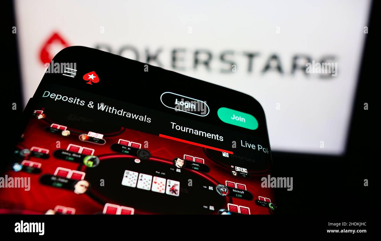 Telefono cellulare con pagina web di poker online Card room PokerStars sullo schermo di fronte al logo business. Mettere a fuoco sulla parte superiore sinistra del display del telefono. Foto Stock