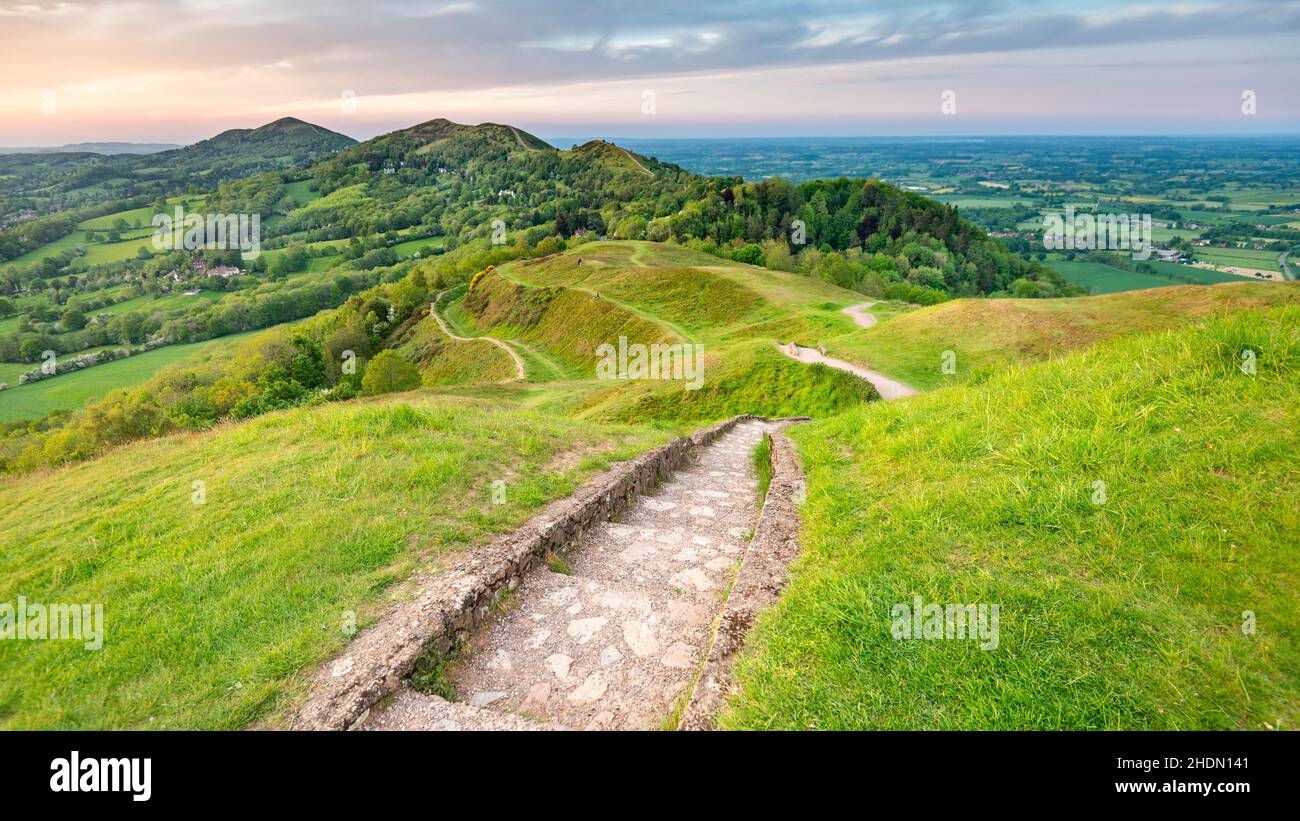 Un'estate sunrise.The sentiero, con gradini sulle pendici più ripide, corre lungo il gambero delle colline di Malvern, con belle vedute attraverso il c circostante Foto Stock