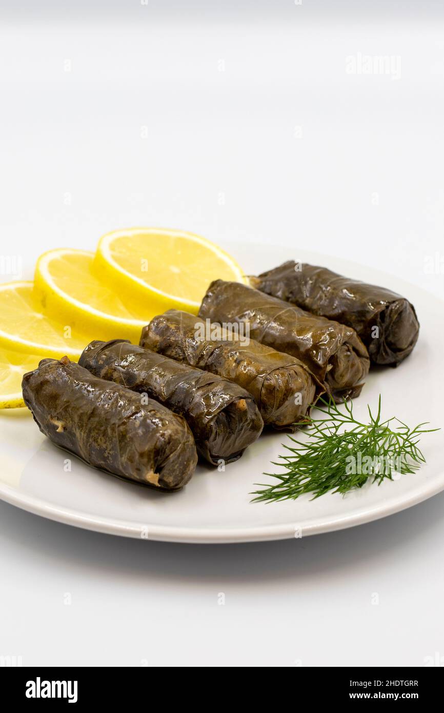 Foglie d'uva farcite con olio d'oliva su sfondo bianco. Prelibatezze della cucina tradizionale turca. Delicious dolma (yaprak sarma). Vista verticale. Clos Foto Stock
