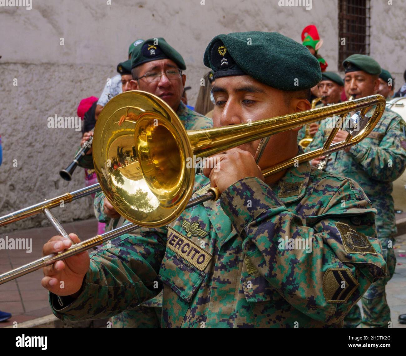 cuenca, Ecuador, 24 dicembre 2021 - gli uomini giocano a trombone nella tradizionale parata itinerante della vigilia di Natale di Pase del Nino. Foto Stock
