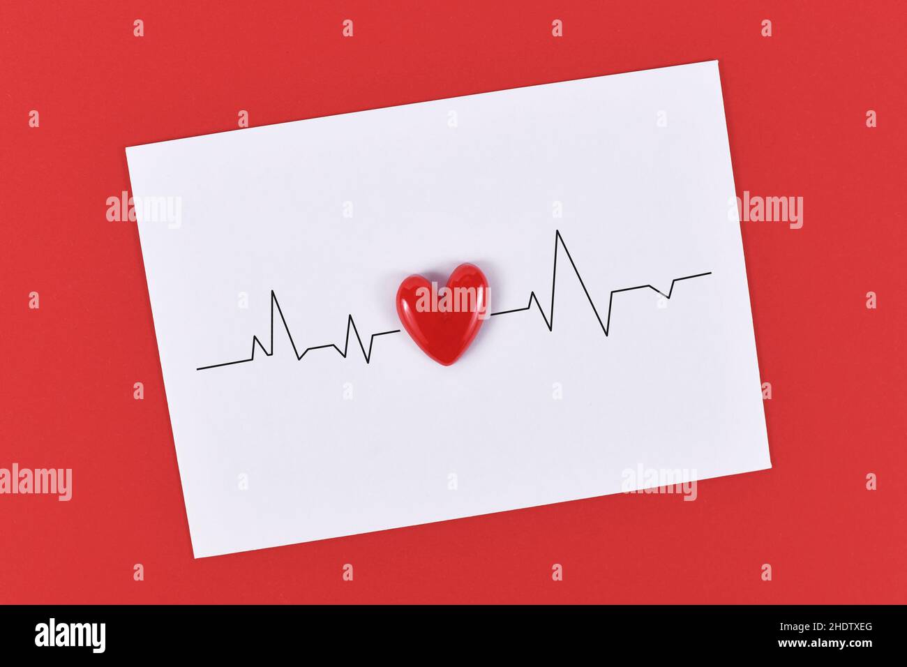 Linea heartbeat e heartbeat su carta bianca nota su sfondo rosso Foto Stock