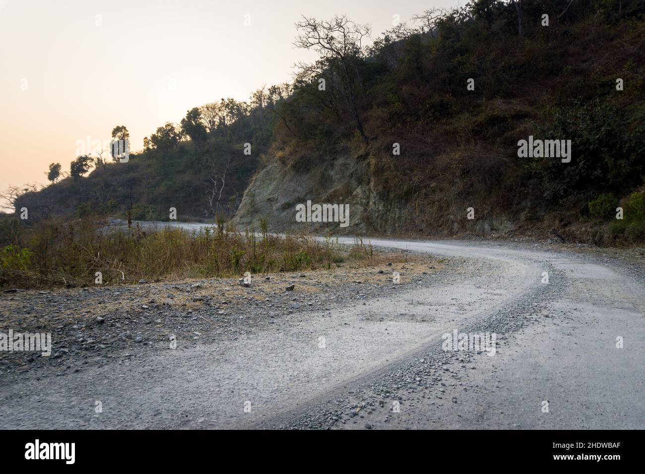 Una strada asfaltata vuota in India rurale circondata da montagne nella bassa Himalaya. Foto Stock