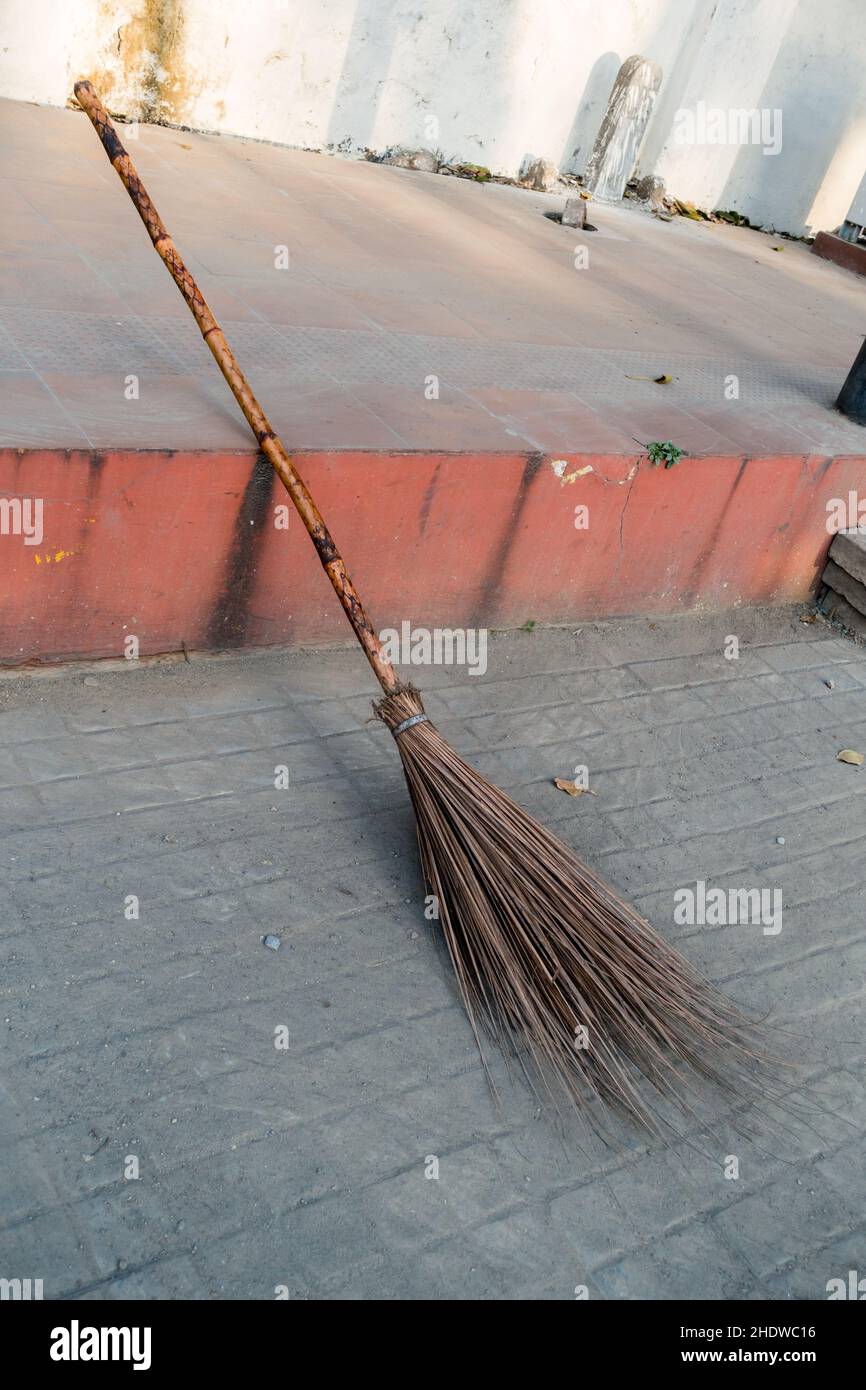 Un primo colpo di scopa usata dai lavoratori per pulire i sentieri in India. Foto Stock