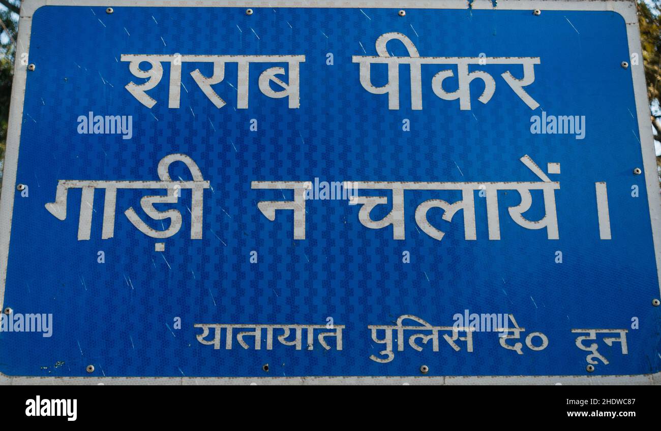 Un bordo stradale con un avvertimento scritto in Hindi in India che traduce ' non bere e guidare' polizia stradale Dehradun. Foto Stock